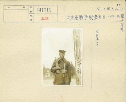 军人抱小狗站在雕像旁.jpg