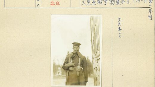 军人抱小狗站在雕像旁.jpg