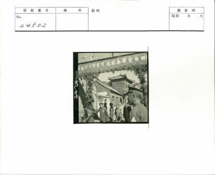 军人走过传统牌坊建筑.jpg