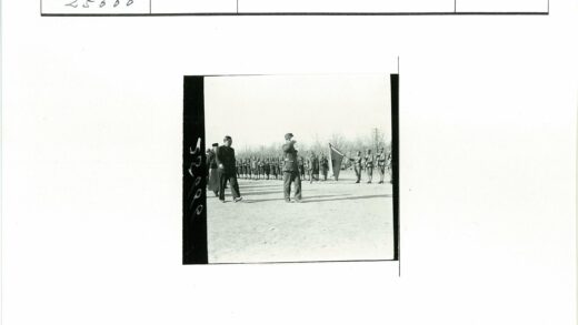 军官与西装男子同行士兵持旗.jpg