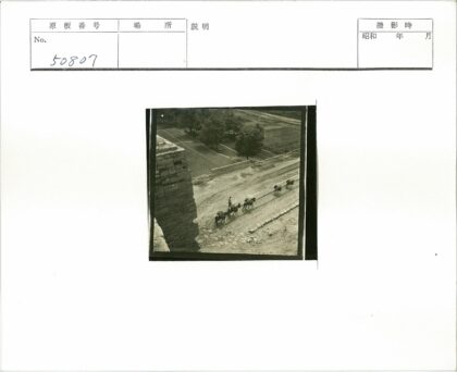 农夫牵驴群走过田野砖房.jpg