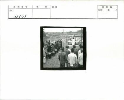 农村男子持帽集会户外场景.jpg