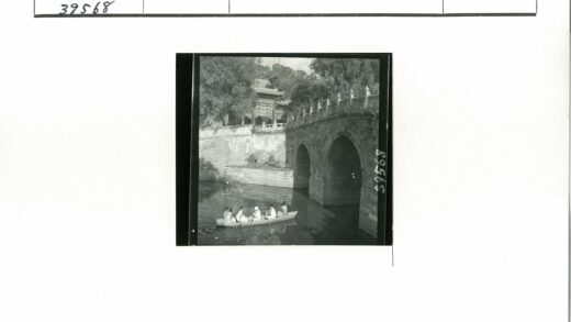 划艇穿行拱桥下绿荫古建.jpg