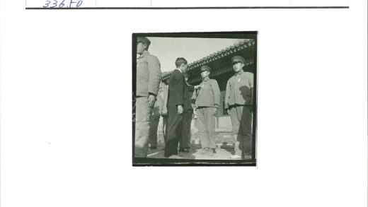 制服与便服男子传统建筑前合影.jpg