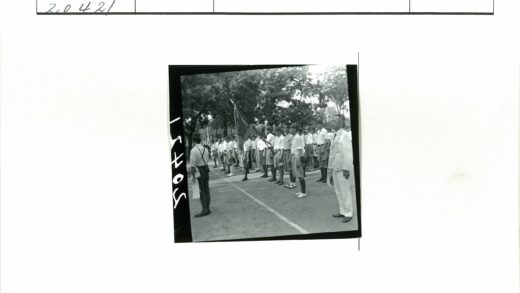 制服与白西装男子持旗列队.jpg