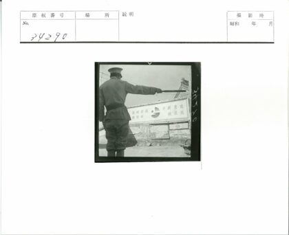 制服人员持棍指向建筑.jpg