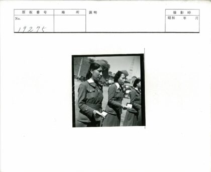 制服女性手持小册子大楼前合影.jpg