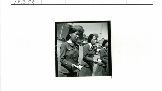 制服女性手持小册子大楼前合影.jpg