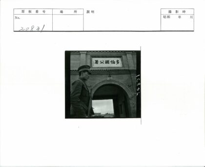 制服男子站拱门建筑前.jpg