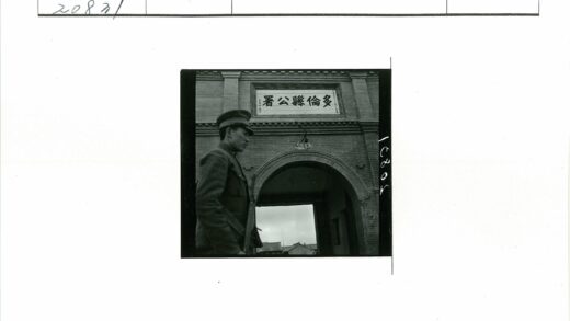 制服男子站拱门建筑前.jpg