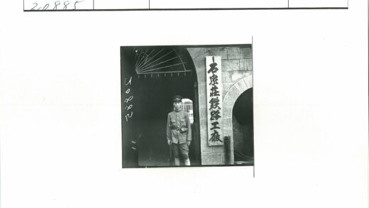 制服男子站石砌建筑汉字木牌前.jpg