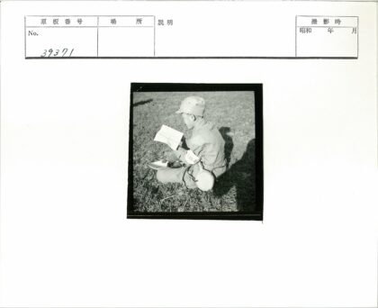 制服男子草地看报挂水壶.jpg