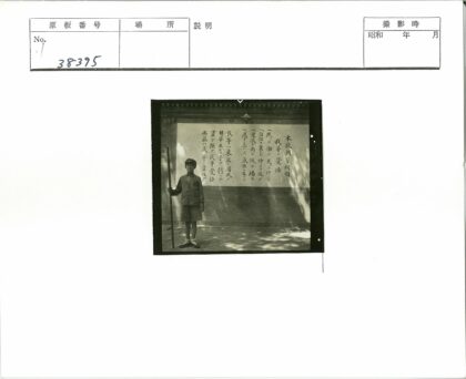 制服男孩持棍站东方文字墙.jpg
