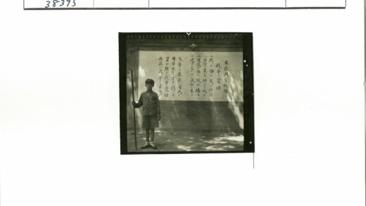 制服男孩持棍站东方文字墙.jpg