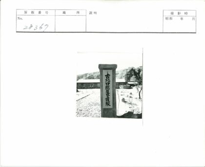刻铭石柱与单层建筑风景.jpg