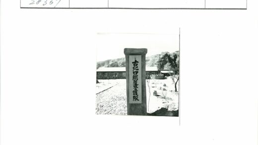 刻铭石柱与单层建筑风景.jpg
