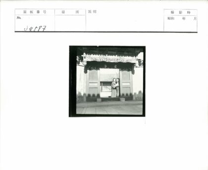华丽木门前的两人与瓦顶建筑.jpg