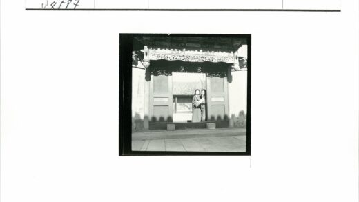 华丽木门前的两人与瓦顶建筑.jpg