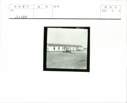 单层白墙建筑与建材堆前景.jpg