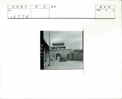 古建筑石门下行驶的汽车.jpg