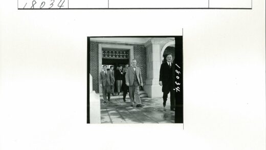 商务人士走出砖砌拱窗建筑.jpg