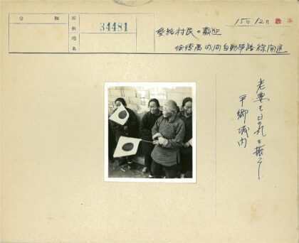四人举圆圈旗站砖墙边.jpg