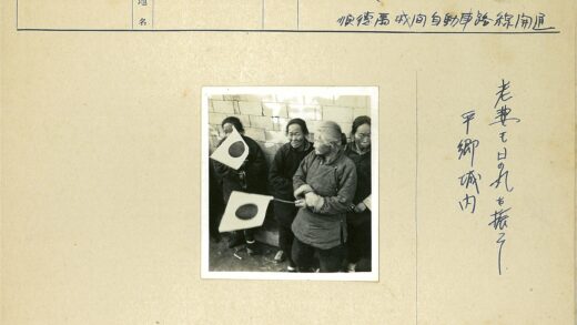 四人举圆圈旗站砖墙边.jpg