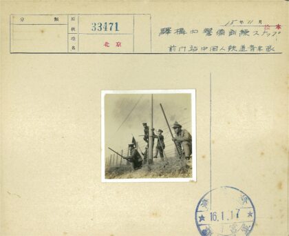 四男子持木杆站铁丝网旁.jpg