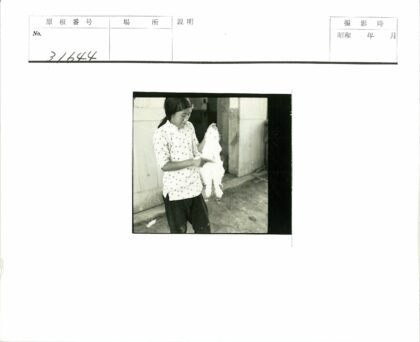 圆点衬衫男子举小白兔建筑前.jpg