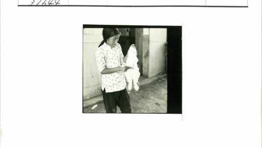 圆点衬衫男子举小白兔建筑前.jpg