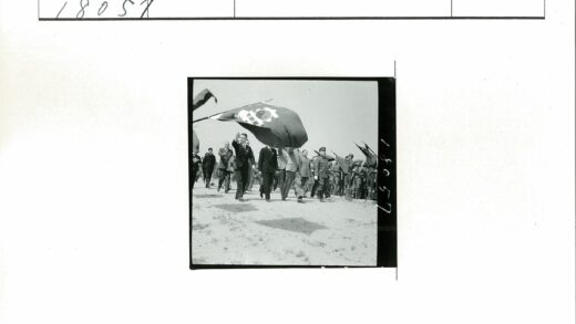 士兵列队举旗沙地行军.jpg