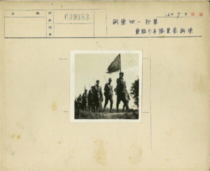 士兵列队举旗草地行军.jpg