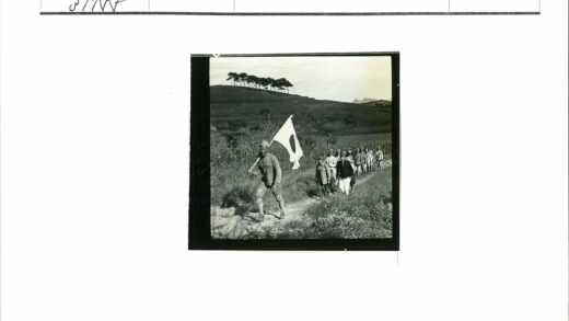 士兵平民举旗泥泞小路行军.jpg