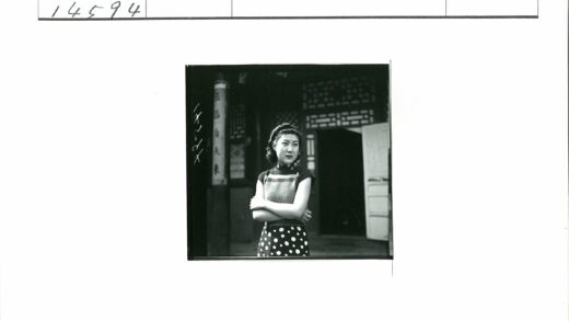 复古卷发女子与木门传统建筑.jpg