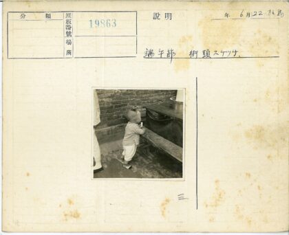 复古发型男孩倚墙站桌凳旁.jpg