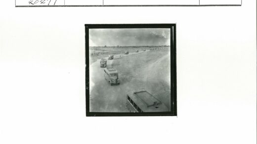 多云天空下土路行驶的公共汽车.jpg