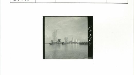 多云天空下帆船航行绿植环绕.jpg