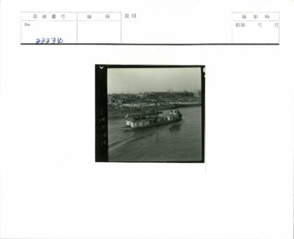 多云天空下河上船只与城市建筑群.jpg