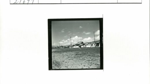 多云天空下草地木杆与传统建筑.jpg