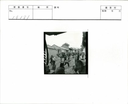 多云天空下骆驼穿行土坯建筑街道.jpg