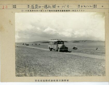 多云泥泞路上公交与奶牛山景.jpg