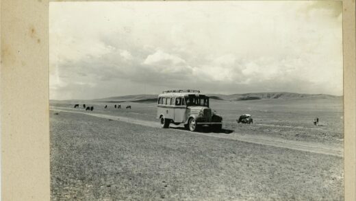 多云泥泞路上公交与奶牛山景.jpg