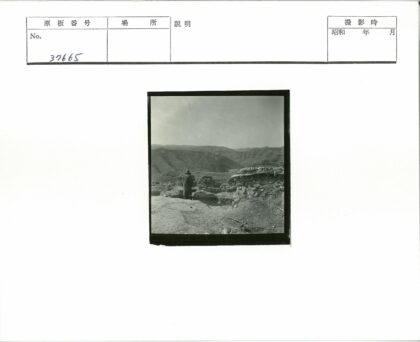 大衣男子伫立古老石墟远山晴空.jpg
