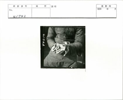 大衣男子手拿小猴子玩具.jpg