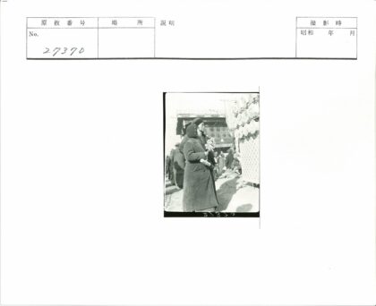 大衣男子持花束站建筑旁.jpg