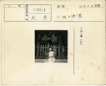 女人持编织帽站瓮前雕像围栏.jpg
