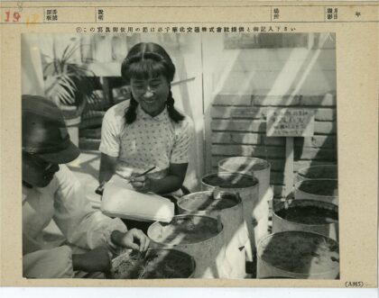 女子微笑记录男子照料植物.jpg