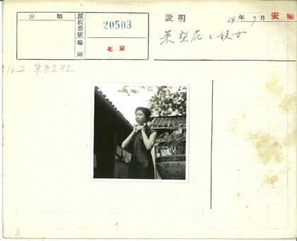 女子持物站瓦屋顶前.jpg