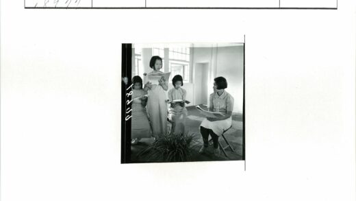 女孩室内读报纸窗前绿植.jpg