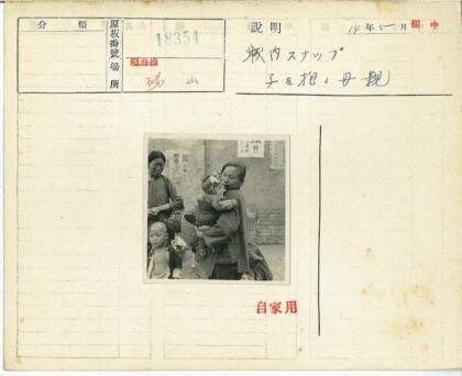 妇女与孩子在砖墙前.jpg